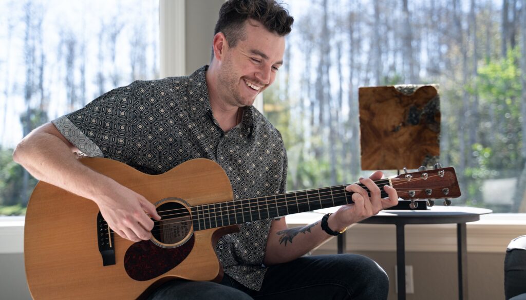 Musician playing acoustic guitar, lifestyle shoot